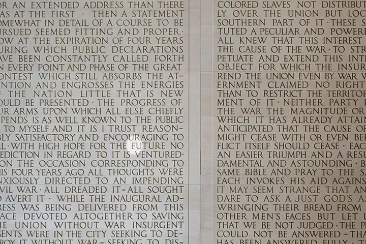 Close-up of carved stone text showing Lincoln's Second Inaugural Address inscribed on memorial wall.