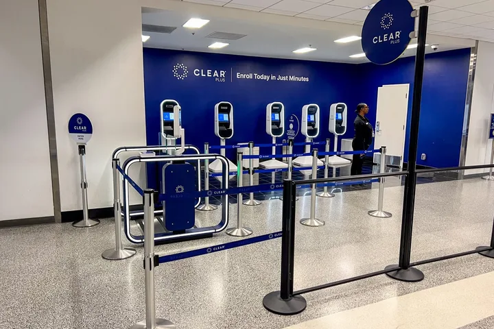 CLEAR Plus biometric enrollment kiosks in an airport with blue branding.