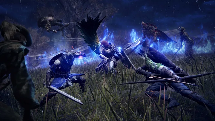 Multiple armored characters battle glowing blue-flamed enemies in a dark nighttime grassy field.