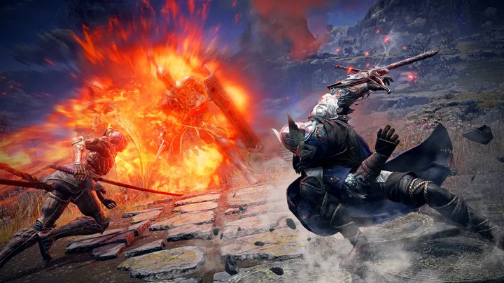 Two armored warriors fight a fiery explosion-engulfed boss enemy on a crumbling stone battlefield.