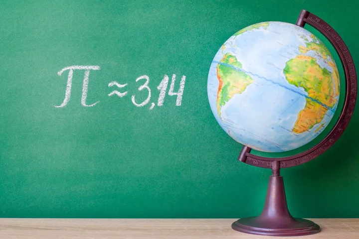 A classroom globe beside a green chalkboard displaying the formula pi approximately equals 3.14.
