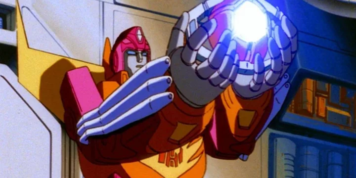 Animated orange Transformer Hot Rod holds a glowing Matrix of Leadership in both hands.