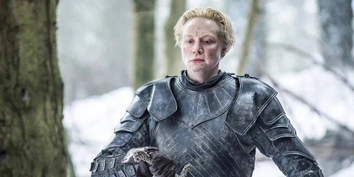 Armored female warrior in full plate mail walking through a snowy forest, determined expression.