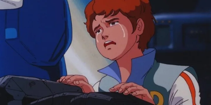 Animated teenage boy with red hair crying near a robot in a spacecraft interior.