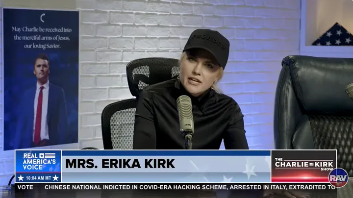 Erika Kirk speaks at a microphone on The Charlie Kirk Show on Real America's Voice, labeled 'Mrs. Erika Kirk'.