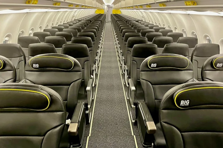 Empty Spirit Airlines cabin showing rows of black seats with yellow BIG Front Seat branding.